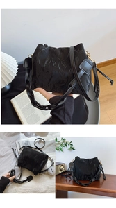 Détail du sac seau noir plissé avec poignée tressée et breloque pompon blanc moelleux