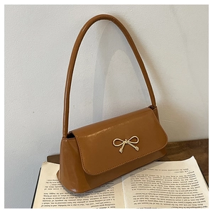 Détail du sac à bandoulière marron en similicuir avec fermoir nœud doré vintage