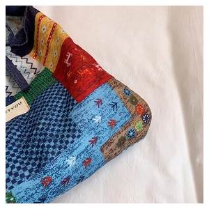 Close-up of Bohemian patchwork denim bag with ethnic patterns and detailed fabric texture