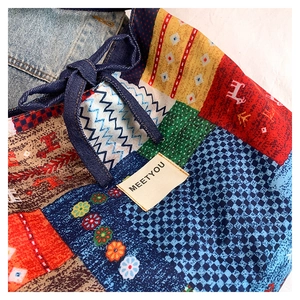 Close-up of colorful ethnic patchwork tote bag with MEETYOU label and denim bow detail