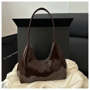Detail of dark brown patent leather hobo bag with glossy finish and logo branding