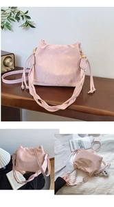 Détail du sac seau rose plissé montrant la poignée tressée et les cordons de serrage