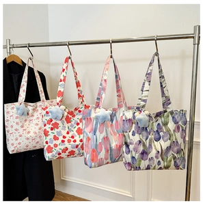Detail of four floral canvas tote bags with star charms on a metal rack display