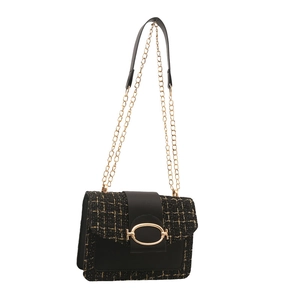Elegant black and gold tweed shoulder bag with a metallic chain strap and oval clasp