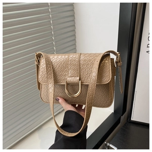 Détail du sac à main beige gaufré crocodile avec boucle en U dorée et bandoulière cuir