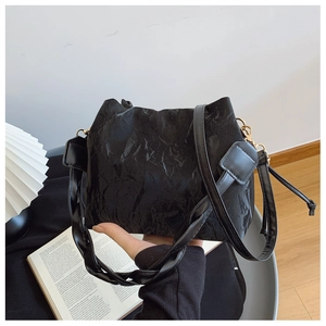 Détails du sac seau noir plissé avec texture souple et finitions métalliques dorées