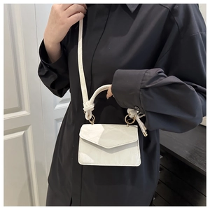 Detail of creamy white small square bag with glossy crinkled leather and gold hardware