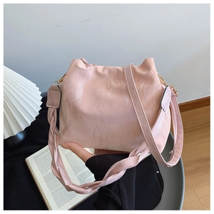Détail du sac seau rose plissé avec poignée tressée et crochets en métal doré