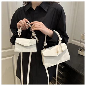 Detail of white marble texture leather handbag with knotted handle and gold hardware