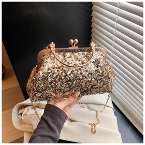 Close-up of gold sequin evening clutch with metal handle and dual bead clasp