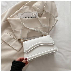 Détail du sac à bandoulière blanc rectangulaire avec matelassage ondulé et boucles dorées