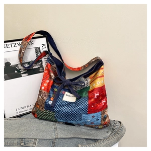 Close-up of patchwork tote bag with colorful ethnic patterns and denim bow detail