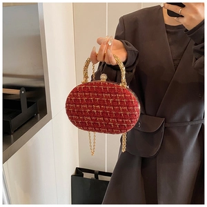 Detail of red tweed evening clutch with crystal clasp and woven metal handle