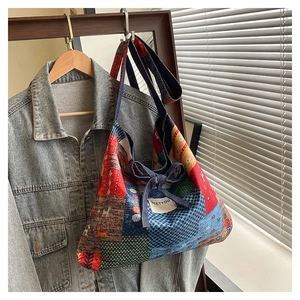 Detail of bohemian patchwork tote bag with various patterns and a ribbon tie