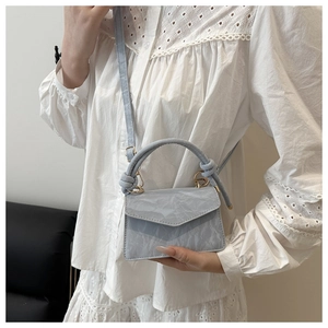 Dettaglio mini borsa azzurra con trama in pelle marmorizzata e fibbie dorate