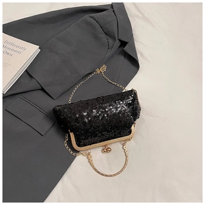 Detail view of black sequin shell clutch bag with gold ring handle and metal chain strap