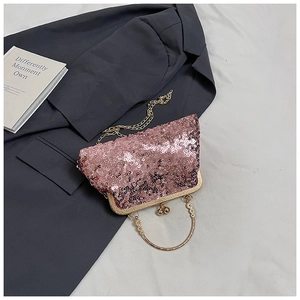 Detail of pink sequin shell bag featuring gold hardware and pearl beaded handle