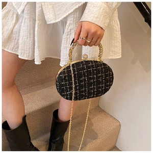 Detailed shot of tweed evening bag with gold ring handle and sparkling crystal clasp