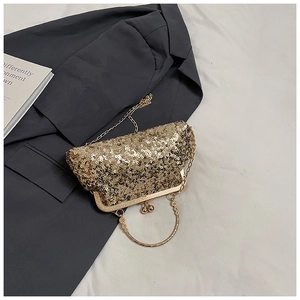 Detailed view of the gold sequin shell bag featuring vintage metal clasp and carved handle