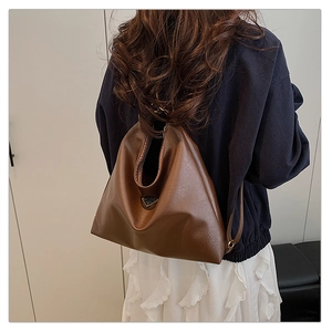 Close-up of brown matte leather hobo bag featuring a triangular metal logo plaque