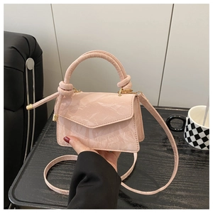 Detail of light pink marble texture handbag with unique knotted handle and slim strap