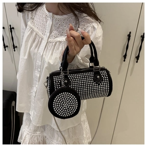 Detail of black cylinder bag with silver studs, matching coin purse and chain strap