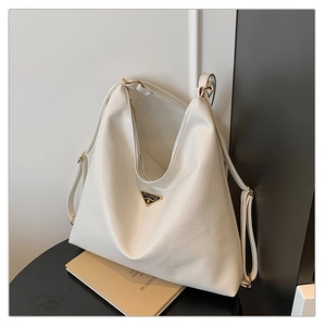 Detail of white lychee texture tote bag with triangle logo on a minimalist background