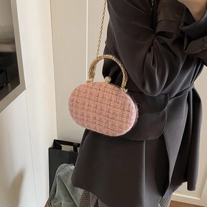 Pink tweed oval clutch bag with gold woven handle and rhinestone bead closure