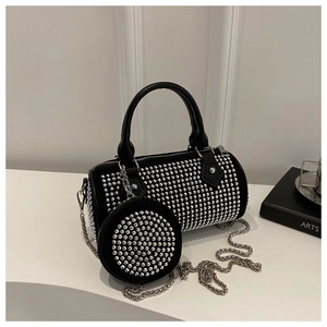 Detail of black studded cylinder handbag set with mini purse and silver chain strap