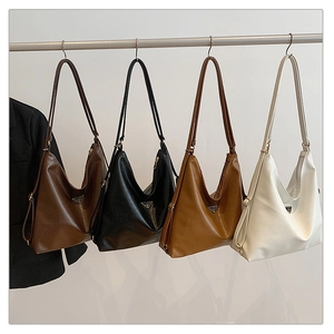 Detail of four colorful vintage hobo bags hanging with iconic triangle metal logo plates