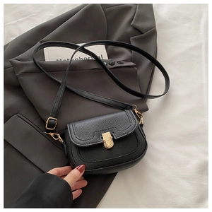 Détail du sac bandoulière vintage noir avec texture litchi et fermoir doré rotatif