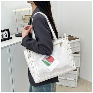 Detail of white ribbon tote bag featuring a transparent PVC window and side lace-up design