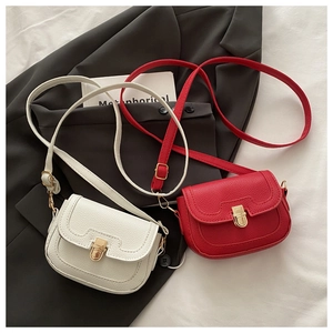Détail de sacs en cuir grainé avec boucle dorée sur fond de blazer noir élégant