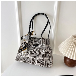 Detail of large striped tote bag with black handles and decorative printed silk scarf