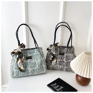 Close-up of striped tote bags with fashion label and silk scarf detail on white table