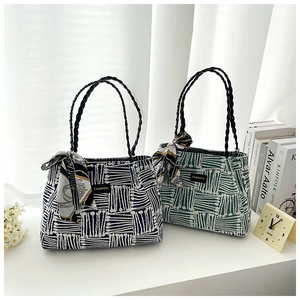 Detail of woven tote bag texture with fashion tag and decorative silk scarf handle