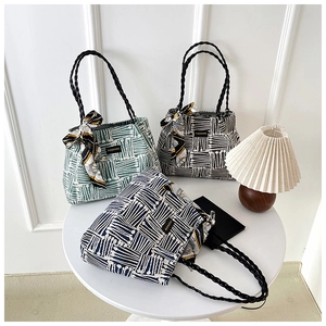 Detailed view of woven canvas tote bags in green, blue, and black stripes with silk scarves