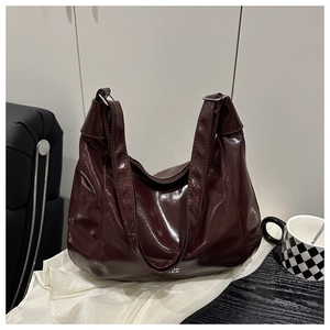 Dettaglio della borsa hobo in vernice bordeaux con finitura lucida e fibbia in argento