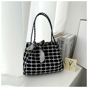 Détail du sac cabas en tweed noir et blanc avec nœud en soie et poignées tressées