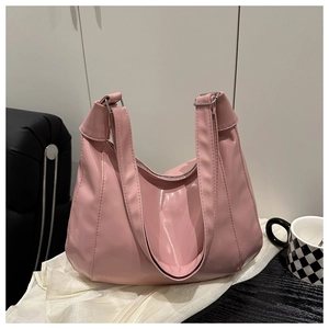 Dettaglio della borsa a spalla in ecopelle rosa lucida con cuciture geometriche e fibbia in metallo