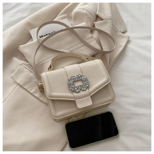 Detail of beige lychee leather bag with crystal buckle and smartphone size reference