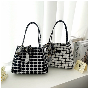 Gros plan de sacs cabas en tweed à carreaux noir et blanc avec détails de foulard en soie