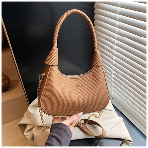 Detail der Webstruktur und Goldkette einer braunen Halbmond-Schultertasche für Damen