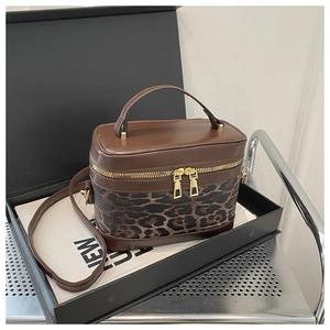 Detailed view of vanity case bag with leopard print and brown leather in a gift box