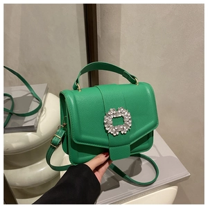Close-up of green lychee leather handbag with crystal-encrusted square buckle detail