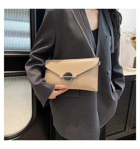 Sac bandoulière beige avec boucle marbrée sur un mannequin pour un style décontracté