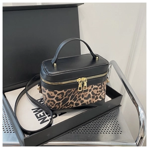 Close-up of leopard print patchwork and dual zipper on a leather mini box crossbody bag