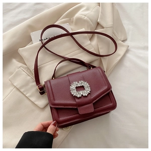 Detailed macro view of the wine red leather texture and sparkling rhinestone buckle
