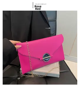 Détail de la pochette enveloppe rose rouge avec chaîne dorée et boucle ronde en métal