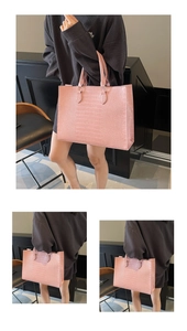 Detail view of pink crocodile-embossed tote bag with double handles and spacious interior